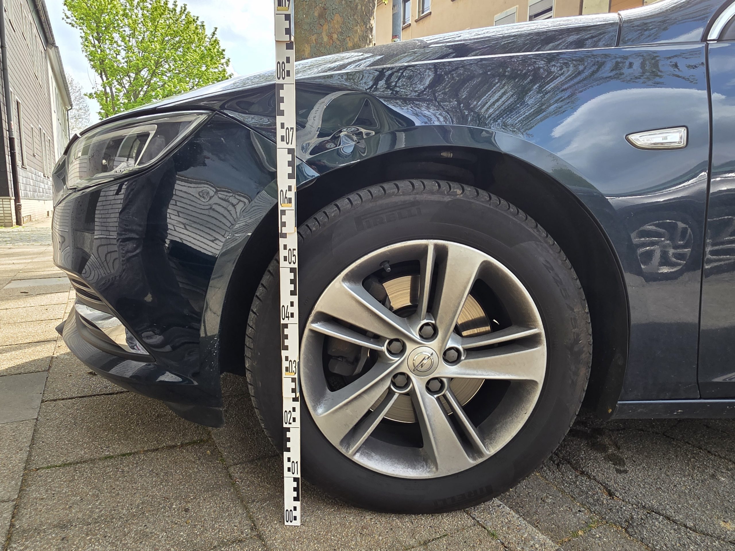 Frontschaden am Fahrzeug mit Messlatte – Kfz Gutachter Aachen dokumentiert Schaden am Radlauf und Stoßfänger